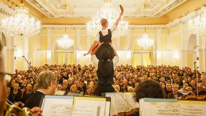 Ballet and orchestra performing in a classical Vienna concert hall.