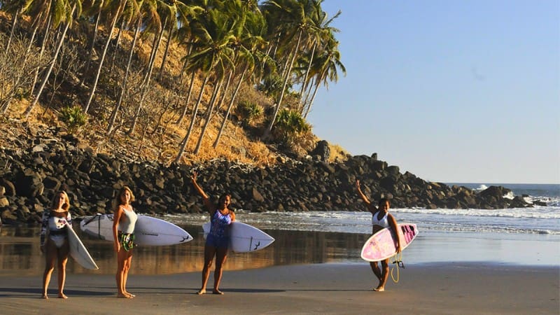 San Salvador Beach Guide: Top Spots And How To Get There 6 Surfers at Playa Las Flores, known for great waves and scenic beach views.