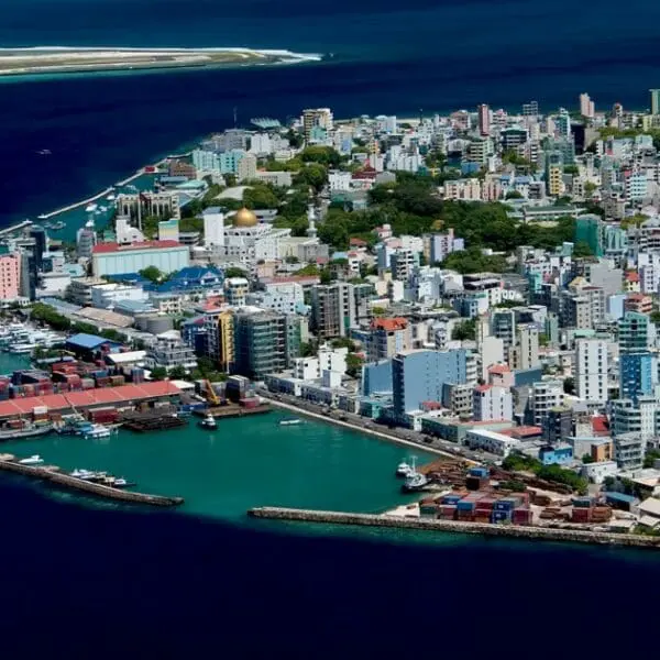 Male travel guide - Aerial view of colorful buildings and bustling port in Male, Maldives.