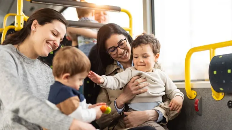 Smiling family rides a bus together on a fun Europe with children holiday.