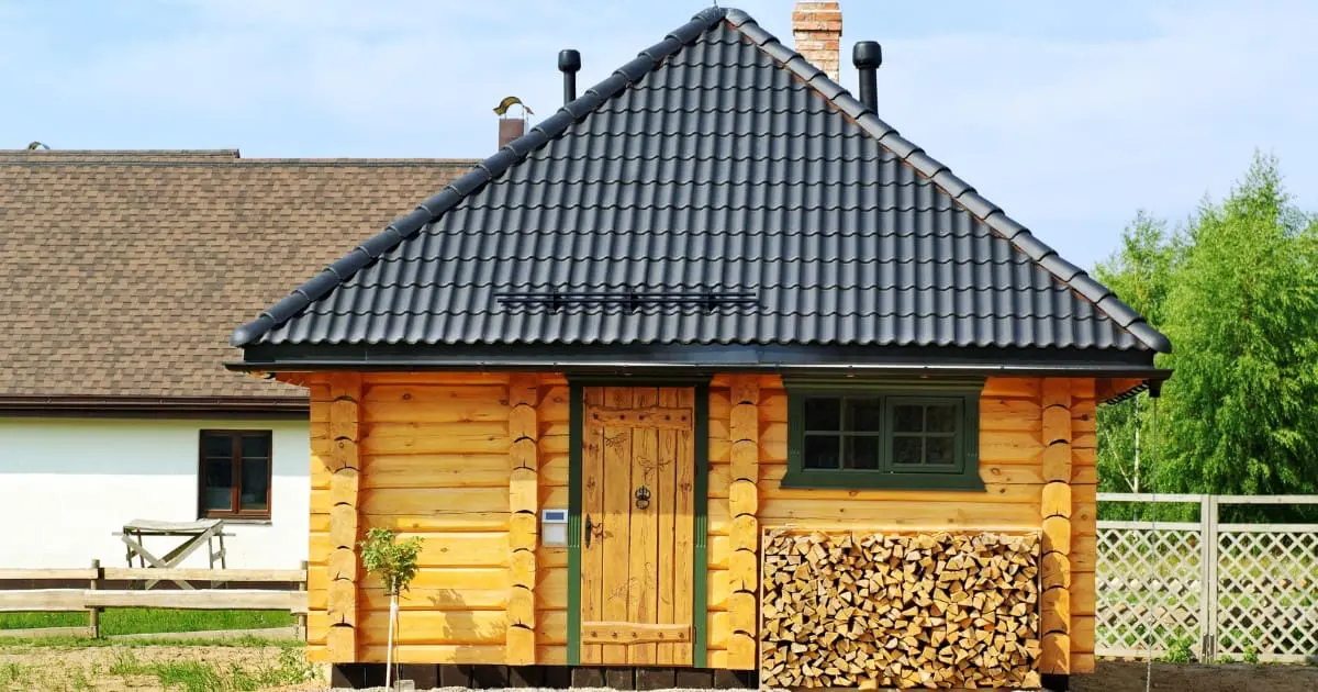 A wooden cabin with a black tile roof serves as a traditional Korean sauna house.