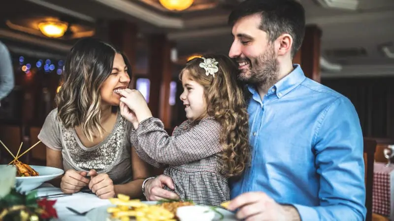 Family enjoys a meal together while exploring dining options in Maui with children.