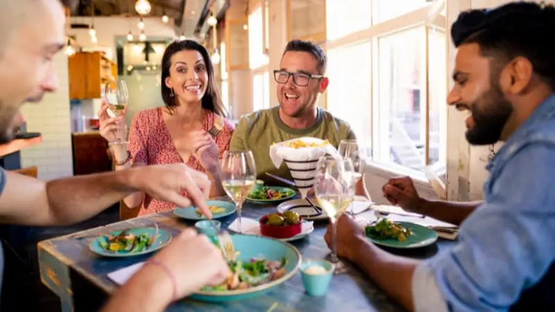 Friends sharing a joyful meal together at a great restaurant in Seminyak, Bali.