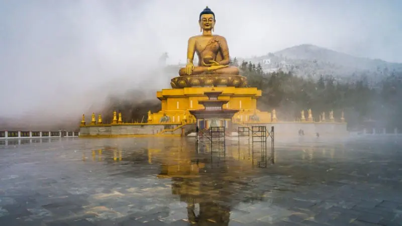 The majestic Buddha Dordenma statue in Thimphu, surrounded by mist and mountains.