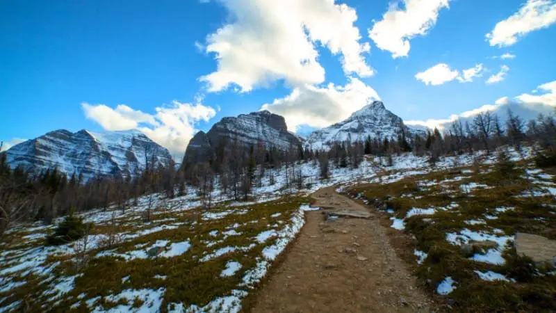 Scenic hiking trail through Banff's snowy mountains, ideal for summer adventures.