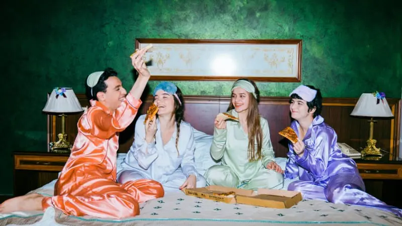 Friends in pajamas enjoying a pizza party during Berlin's Pajama Party event.