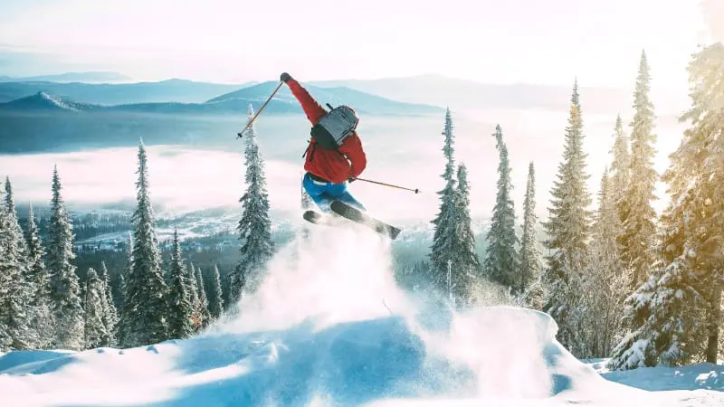 Freestyle skier jumping at dawn in Austria's snow-covered mountains