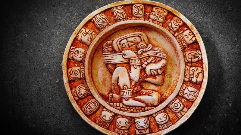 Carved Mayan stone calendar with intricate glyphs, depicting ancient culture.