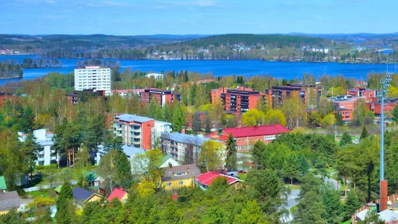 A city with many buildings and a lake surrounded by forests in Jyväskylä.