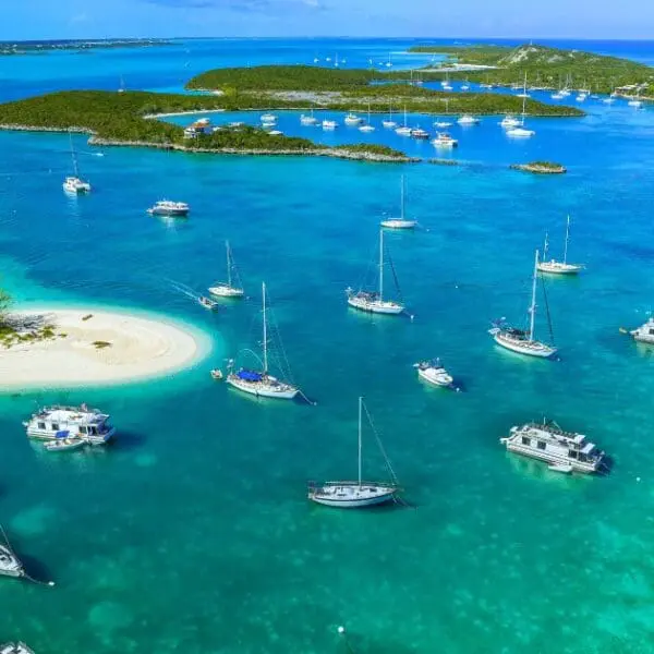 Aerial view of Exuma Cays clear waters, islands, and anchored boats.