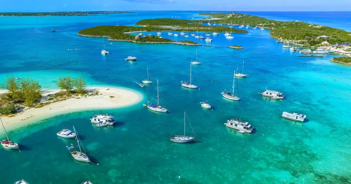 Aerial view of Exuma Cays clear waters, islands, and anchored boats.
