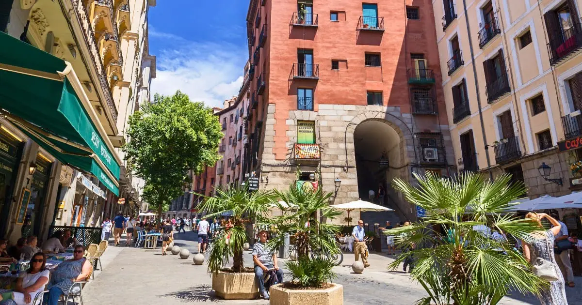 Vibrant street in Madrid with cafes and shops, perfect for people-watching.