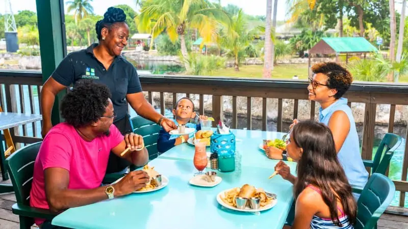 Family eats at outdoor table in Cayman Islands.