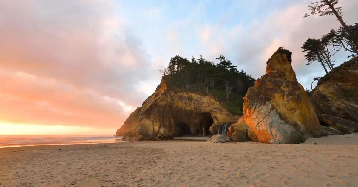 Dramatic sea cave and rock formations at Hug Point Cannon Beach, at sunset.