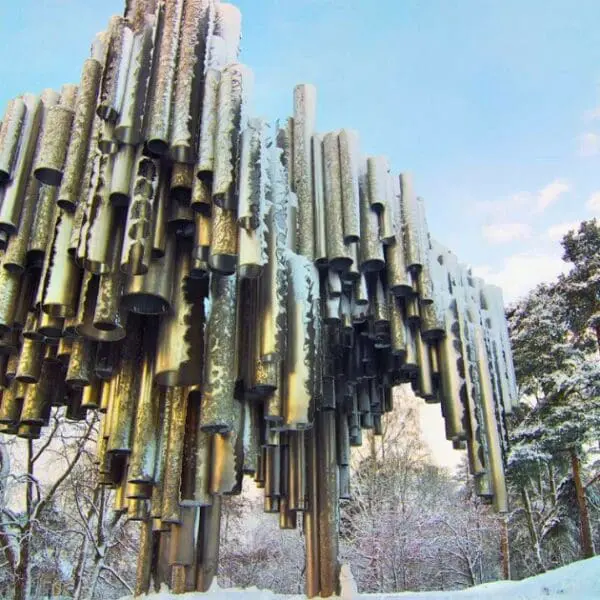 Sibelius Monument in winter, its steel pipes covered in snow against a blue sky.