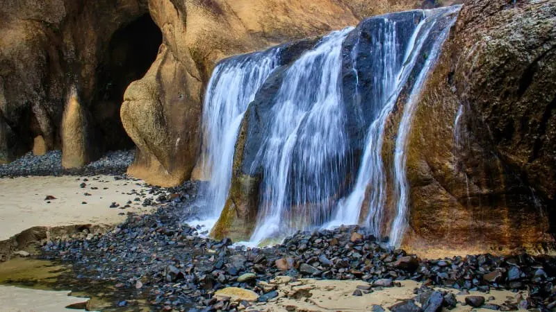 Waterfall cascading onto a beach at Hug Point near Cannon Beach.