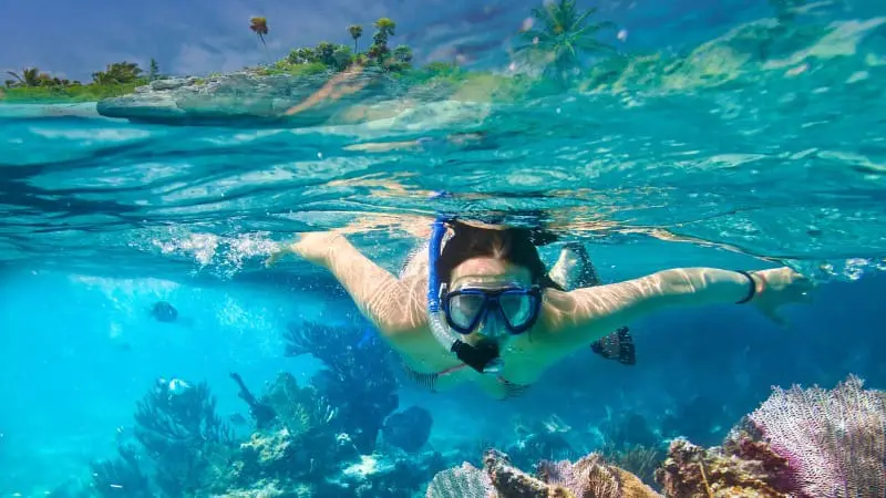 Snorkeler exploring coral reefs in Mamanuca Islands' crystal-clear waters.