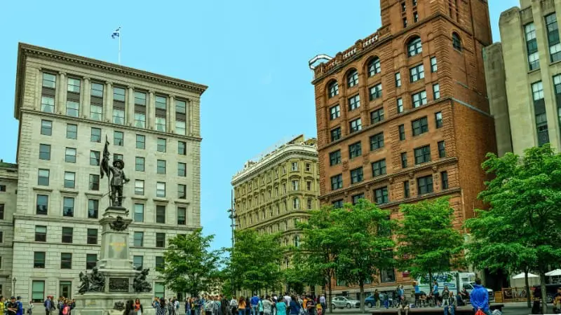 Place d'Armes with historic buildings near Notre Dame Basilica in Old Montreal.