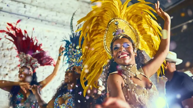 Enjoy carnival dancers in colorful feathered costumes performing.