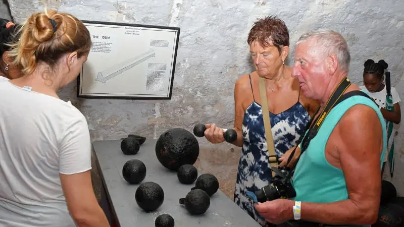 Tourists examining historical artifacts at Barbados Garrison.