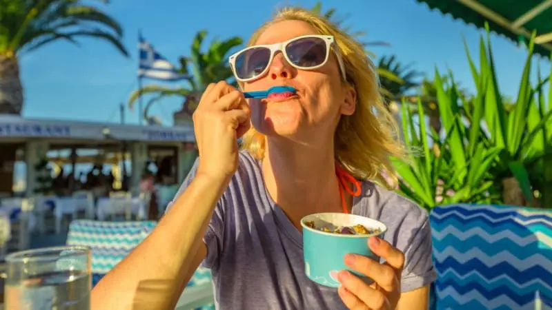 Woman eating Cyprus food on a sunny day in Cyprus, a popular vacation activity.