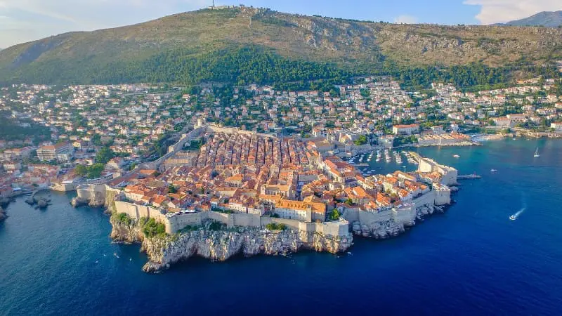 Aerial view of Dubrovnik's walled Old Town jutting into the blue Adriatic Sea.