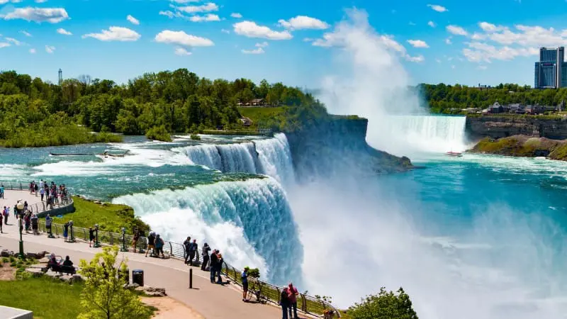 Visitors enjoy Niagara Falls view on sunny day.