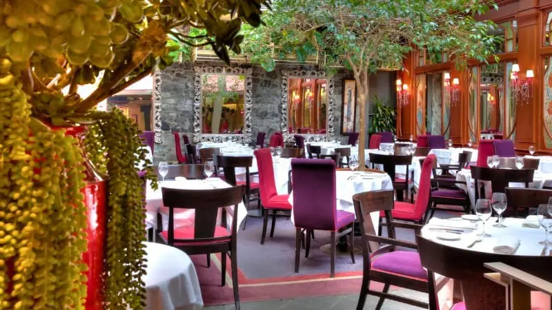 Dining area at Le Saint-Amour with lush decor.