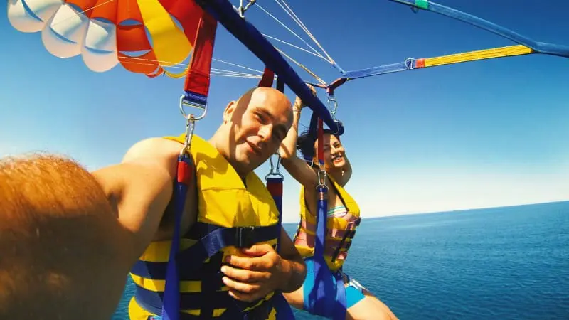 A couple enjoying a thrilling parasailing experience over Calangute Beach.