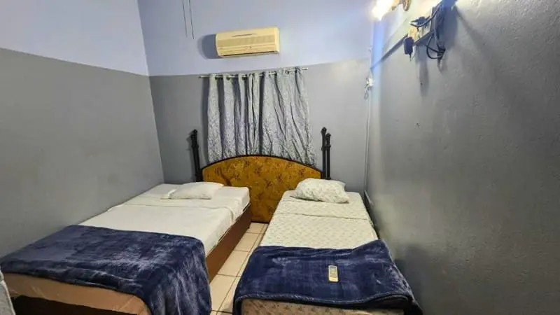 Simple twin bedroom at Reyogee Apartments for budget stay.