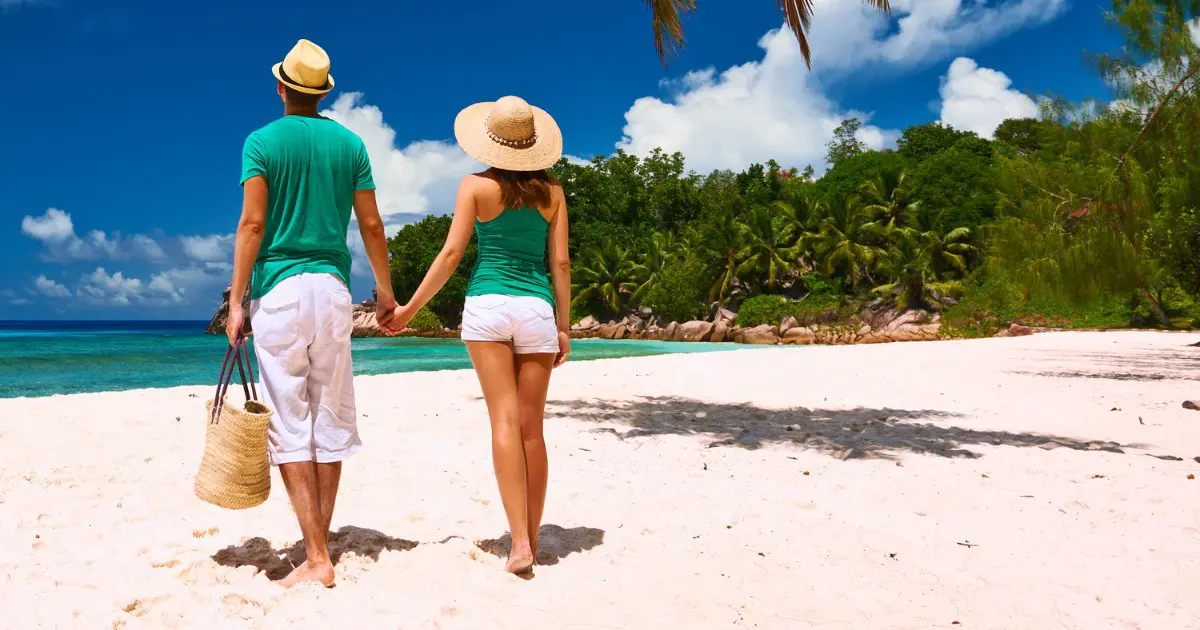 Couples stroll on pristine beaches during their romantic Seychelles honeymoon.
