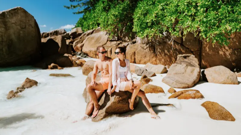 Couples enjoy secluded beaches with giant rocks on their Seychelles honeymoon.