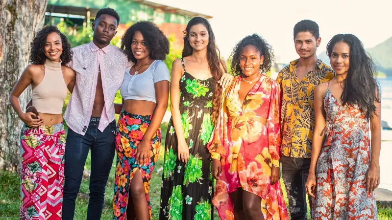 Group of friends enjoying a sunny day by the beach on a Seychelles vacation.