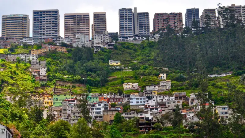 Quito's hillside with colorful homes and modern buildings, offering a unique city view.