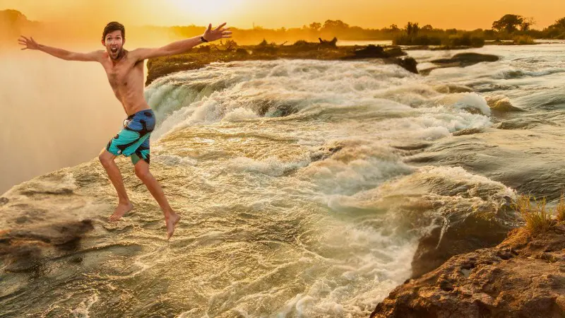 Visitor taking a thrilling leap at Devil’s Pool, a top activity during dry season.