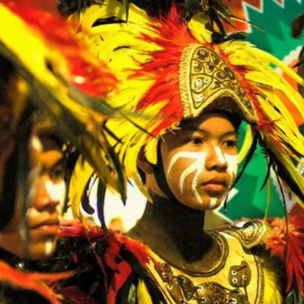 Warrior dancer wearing bright feathers and face paint at Dinagyang Festival