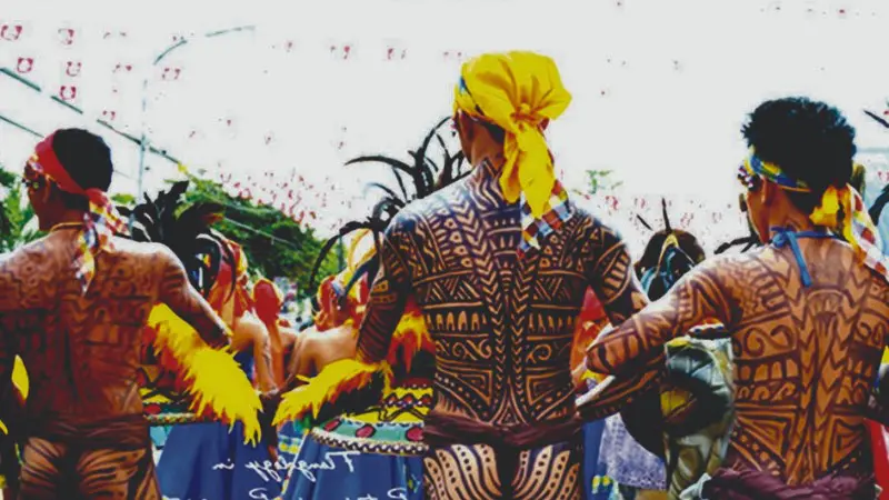 Tribal dancers with traditional tattoo designs at Pintados Festival