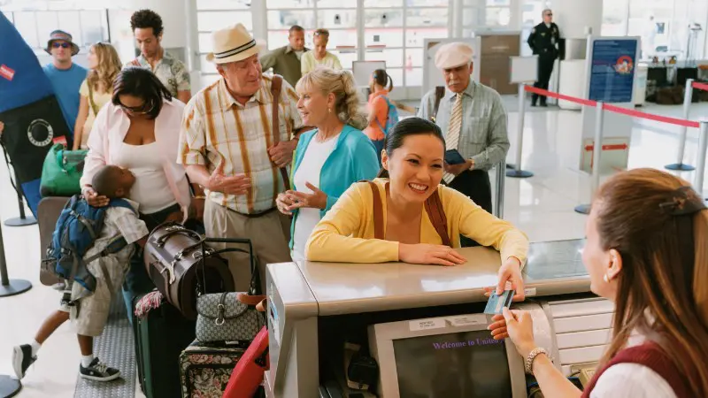 Happy traveler using elite status benefits at airport check-in.