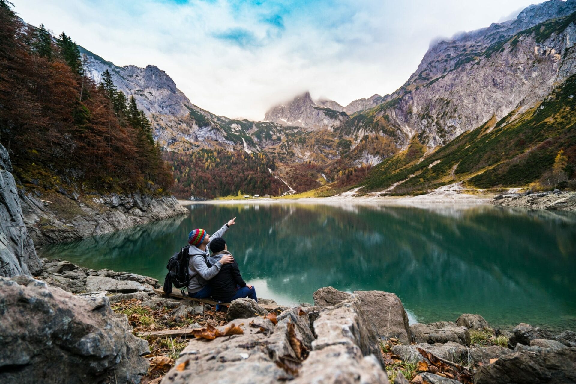 Image of a couple viewing a lake surrounded by mountains