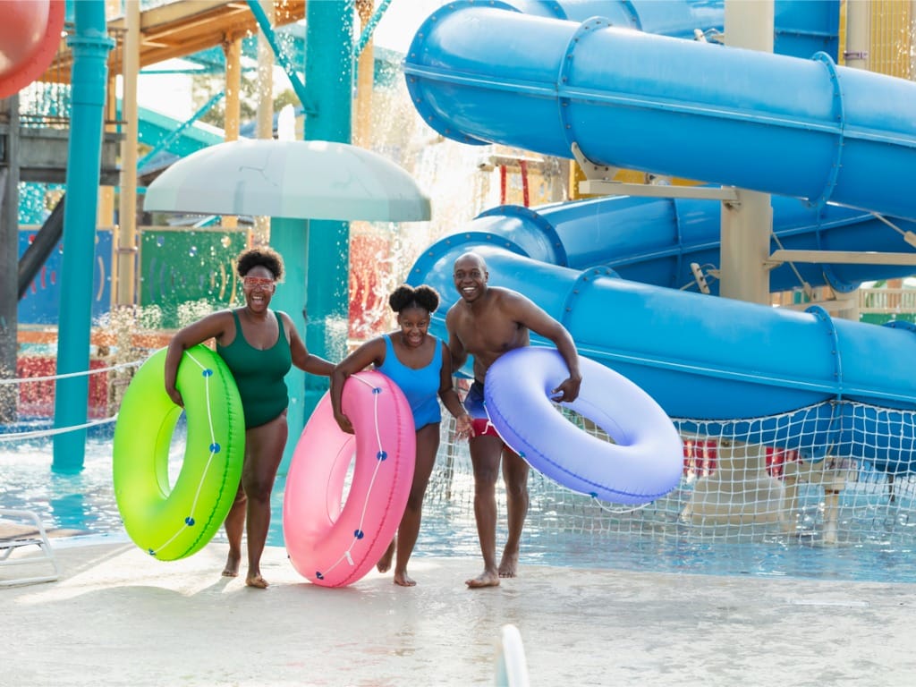 Family at water park carrying inflatable rings
