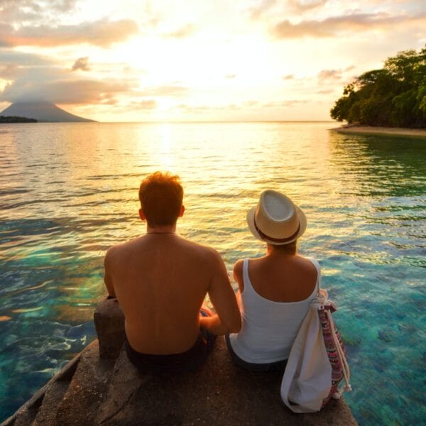couple sitting on rocks watching sunset