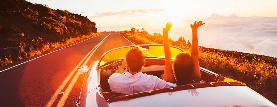 couple in convertible car during sunset