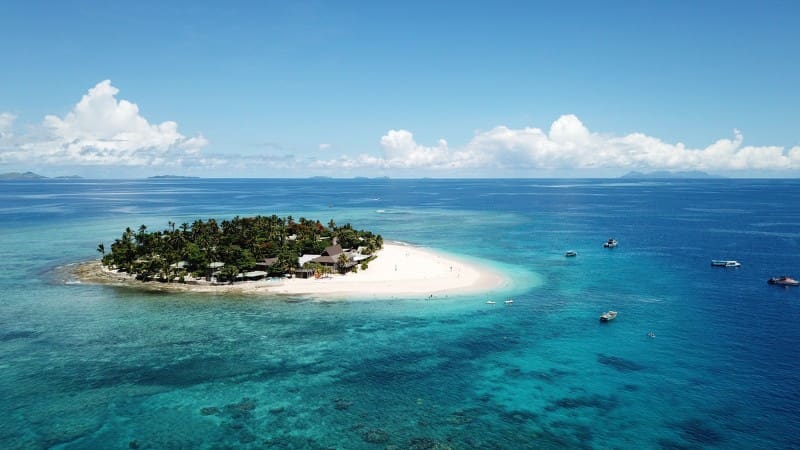 A private island getaway at a secluded adult-only resort in Fiji, featuring pristine beaches and clear waters.