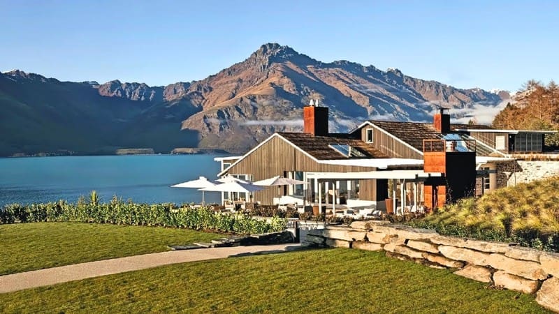 Breathtaking view of mountains and a serene lake from a premium New Zealand lodge, ideal for a luxurious getaway.