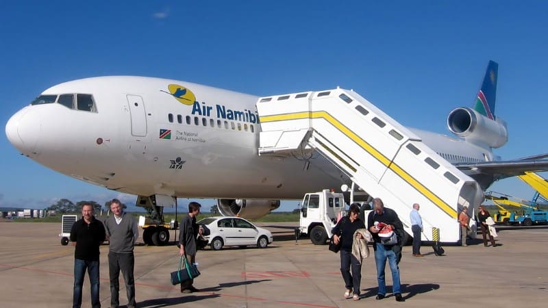 Passengers disembarking an Air Namibia plane, the gateway to exploring Namibia's landscapes.