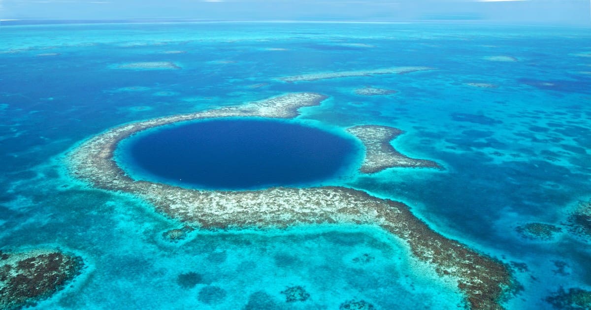 Expansive aerial view showcasing the Great Blue Hole and its surrounding turquoise waters.