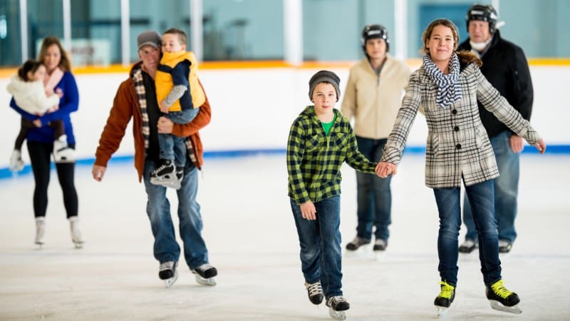 A family enjoying ice skating together, a fun thing to do in Aspen during winter.