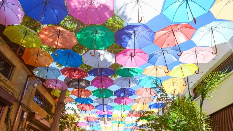 A vibrant display of colorful umbrellas hangs above a street, adding to the charm of things to do in Nicosia.