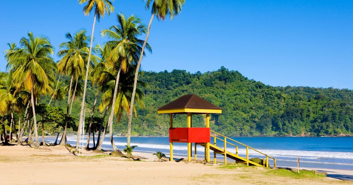 Tourist attractions in Trinidad and Tobago - Pristine beach with a lifeguard hut and palm trees at Maracas Bay.