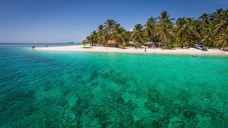 Pristine Caribbean beach in Panama with turquoise waters and white sand, perfect for visiting during the dry season for sun-seekers and beach lovers.